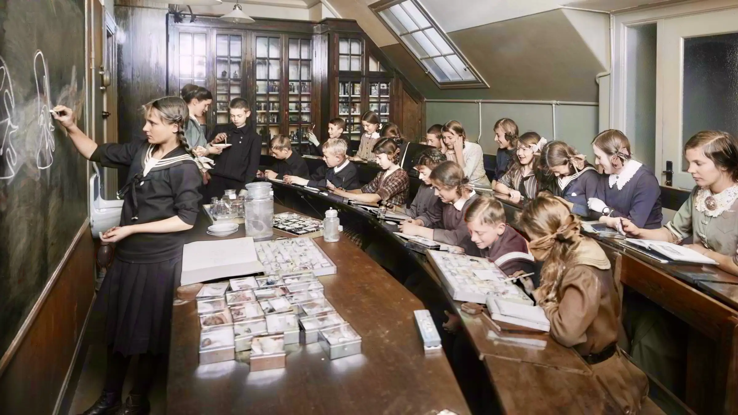 Undervisning i biologisalen vid Withlockska samskolan, Eriksbergsgatan i Stockholm, foto taget ca 1905 - 1920. Källa: Stockholms stadsmuseum. Colorerat svartvitt foto.